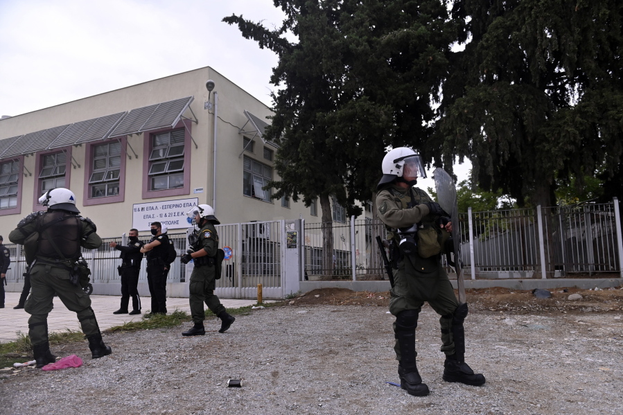 Riot police guard outside a vocational high school after clashes in the northern city of Thessaloniki, Greece, Wednesday, Sept. 29, 2021. Police in the second largest city of the country have arrested five people and detained at least 20 others following clashes involving youths backed by an extreme right-wing political group.