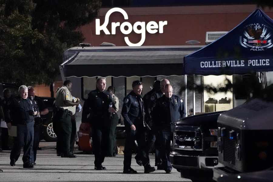 Law enforcement personnel work in front of a Kroger grocery store as an investigation goes into the night following a shooting earlier in the day on Thursday, Sept. 23, 2021, in Collierville, Tenn. Police say a gunman attacked people in the store and killed at least one person and wounded 12 others before the suspect was found dead.