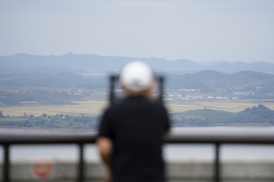 A visitor uses binoculars to see the North Korean side from the unification observatory in Paju, South Korea, Tuesday, Sept. 28, 2021. North Korea fired a short-range missile into the sea early Tuesday, its neighboring countries said, in the latest weapon tests by North Korea that has raised questions about the sincerity of its recent offer for talks with South Korea.