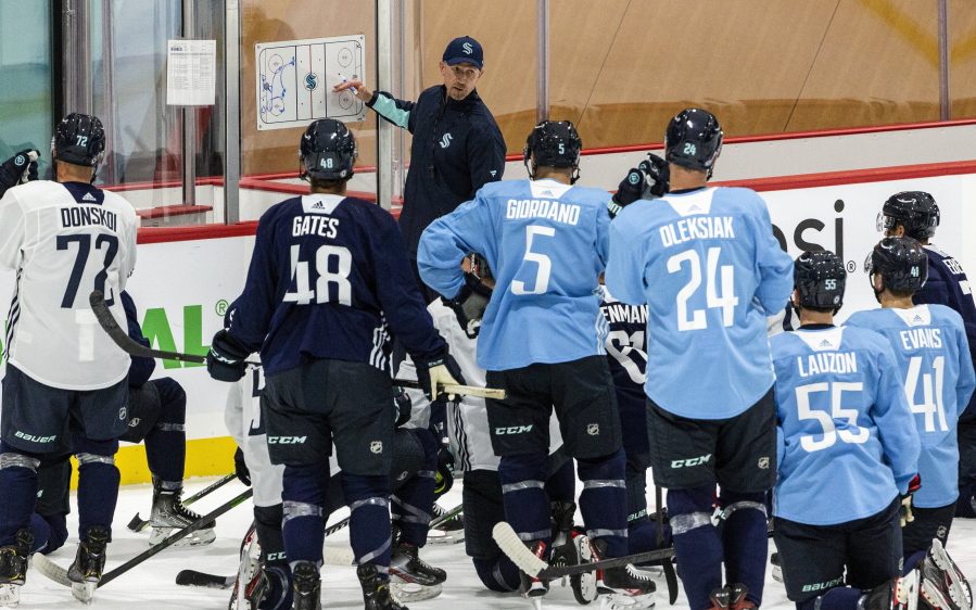 Seattle Kraken head coach Dave Hakstol goes over a drill with players during NHL hockey training camp at Kraken Community Iceplex on Thursday, Sept. 23, 2021, in Seattle.