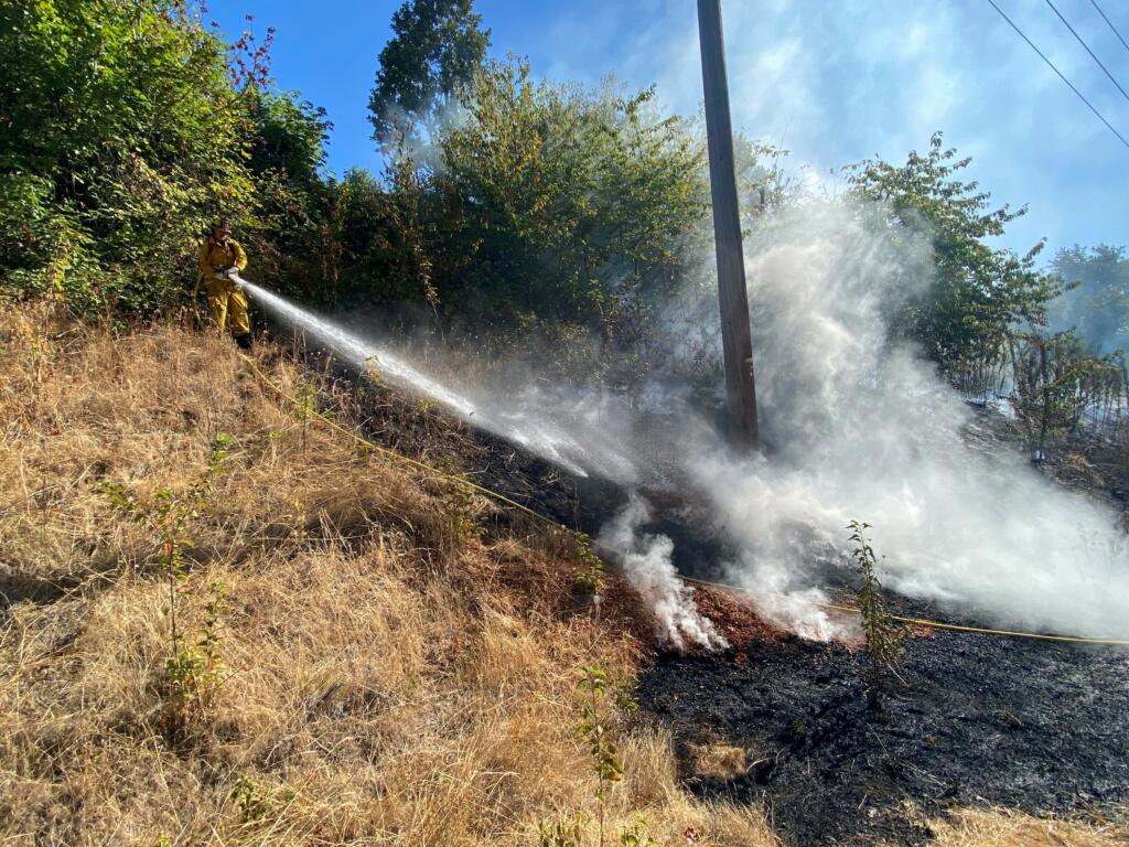 A brush fire on the hillside above Northwest Lakeshore Avenue Wednesday morning threatened two houses.