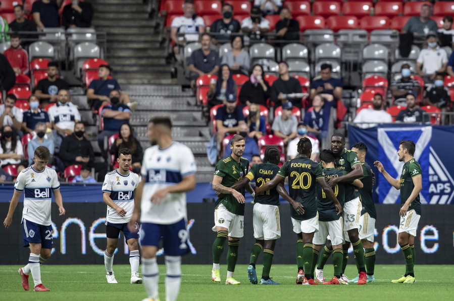 Portland Timbers players celebrate after a Vancouver Whitecaps own goal during the second half of an MLS soccer match Friday, Sept. 10, 2021, in Vancouver, British Columbia.
