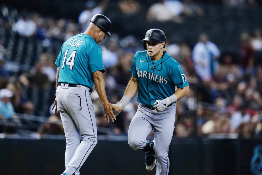 Seattle Mariners' Jarred Kelenic, right, celebrates his two-run home run against the Arizona Diamondbacks with Mariners third base coach Manny Acta (14) during the sixth inning of a baseball game Friday, Sept. 3, 2021, in Phoenix. (AP Photo/Ross D.