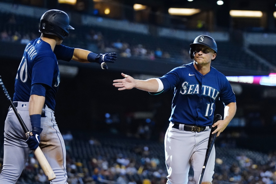 Seattle Mariners' Kyle Seager (15) celebrates his run scored against the Arizona Diamondbacks with teammate Jarred Kelenic (10) during the 11th inning of a baseball game Sunday, Sept. 5, 2021, in Phoenix. (AP Photo/Ross D.