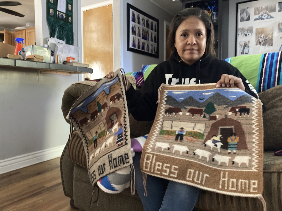 Seraphine Warren poses for a photo in her home in Tooele, Utah, on Sept. 23, 2021, with a rug made by her aunt, Navajo rug weaver Ella Mae Begay. Begay, 62, disappeared in June, one of thousands of missing Indigenous women across the U.S. The extensive coverage of the Gabby Petito case is renewing calls to also shine a spotlight on missing people of color.