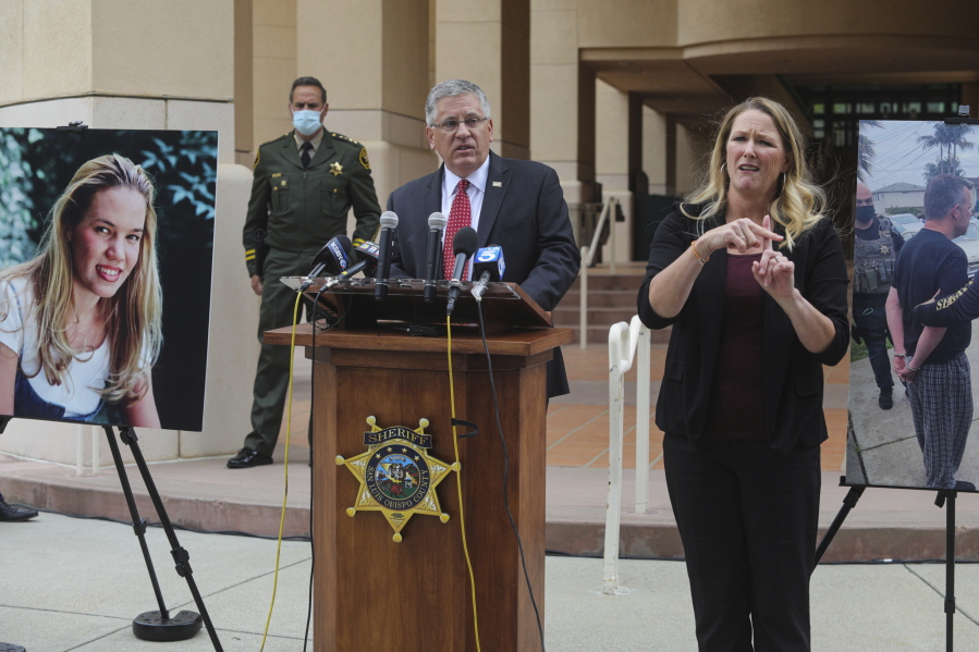 FILE - In this April 13, 2021, file photo, Cal Poly President Jeffrey Armstrong, center, speaks during a news conference in San Luis Obispo, Calif. At left is a photo of student Kristin Smart. A California judge is expected to rule Wednesday, Sept. 22, 2021, whether a father and son face trial on charges related to the disappearance 25 years earlier of Smart.