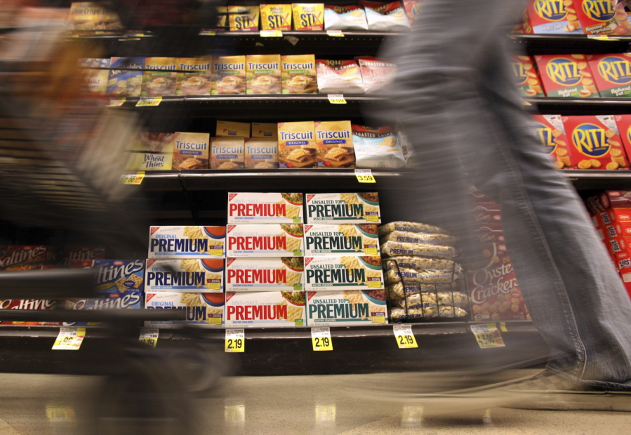 FILE - In this Feb. 9, 2011, file photo, a shopper passes a shelf of Nabisco products, a Mondelez International brand: Premium saltines, Triscuits, Ritz crackers and Wheat Thins, at a Ralphs Fresh Fare supermarket in Los Angeles. A tentative contract agreement reached between snack company Mondelez and striking union workers could end a walkout that began last month. The Bakery, Confectionery, Tobacco Workers and Grain Millers International Union and Mondelez issued separate statements Wednesday, Sept. 15, 2021, announcing a tentative deal, but neither would discuss the terms, The Richmond Times-Dispatch reported.