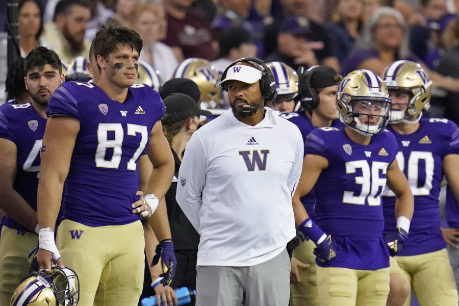Washington head coach Jimmy Lake, center, stands on the sidelines late in the second half of Saturday's loss to 13-7 Montana in Seattle.