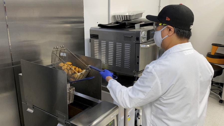 Nathan Foot, R&D chef at Impossible Foods, takes its new meatless nuggets out of a deep fryer in the company's test kitchen on Sept. 21, 2021 in Redwood City, Calif. The plant-based nuggets taste are designed to taste like chicken.