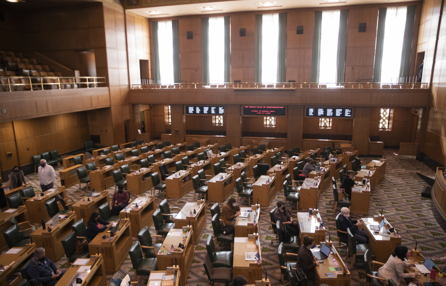Oregon State Representatives congregate in the House, prior to the meeting being adjourned due to a COVID-19 exposure, during a special legislative session for redistricting congressional maps, Tuesday, Sept.