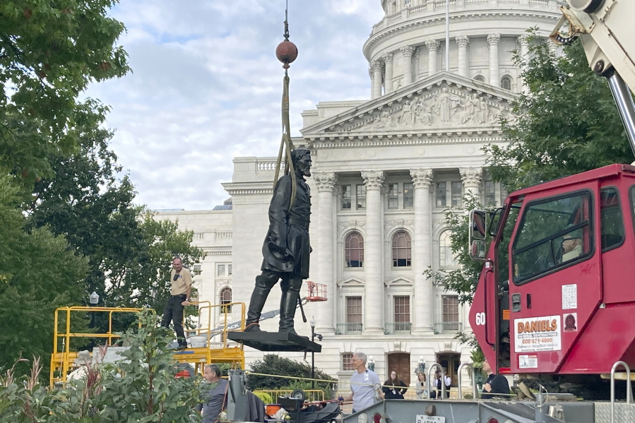 Workers reinstall a statue of Wisconsin abolitionist Col. Hans Christian Heg outside the state Capitol in Madison, Wis., on Tuesday, Sept. 21, 2021. Protesters tore the 9-foot-6-inch statue down and ripped its head off in June 2020 during a demonstration over George Floyd's death in Minneapolis.
