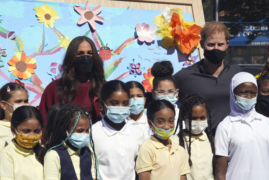 Prince Harry and Meghan, the Duke and Duchess of Sussex, pose for photos with a group of third grade students during their visit to P.S. 123, the Mahalia Jackson School, in New York's Harlem neighborhood, Friday, Sept. 24, 2021.