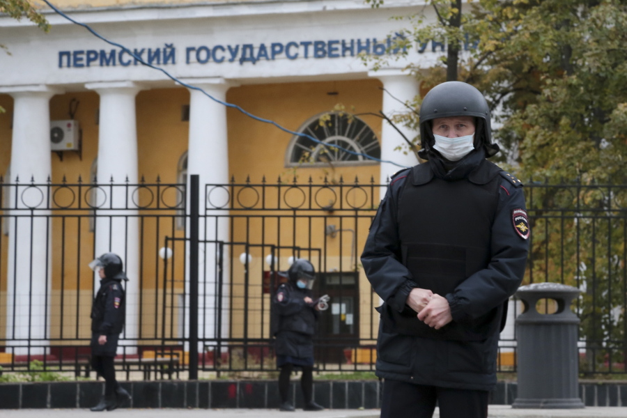 Police officers guard an area in front of the Perm State University in Perm, about 1,100 kilometers (700 miles) east of Moscow, Russia, Monday, Sept. 20, 2021. A gunman opened fire in a university in the Russian city of Perm on Monday morning, leaving at least eight people dead and others wounded, according to Russia's Investigative Committee.