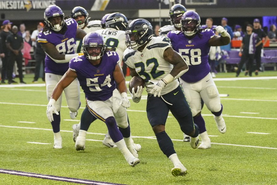 Seattle Seahawks running back Chris Carson (32) runs for a touchdown in front of Minnesota Vikings middle linebacker Eric Kendricks (54) and defensive tackle Michael Pierce (58) in the first half of an NFL football game in Minneapolis, Sunday, Sept. 26, 2021.