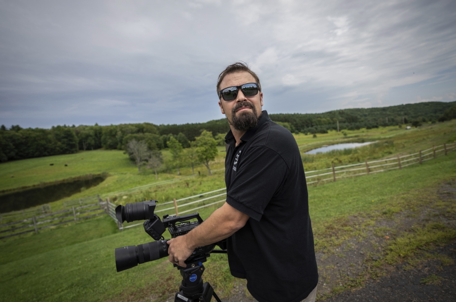 Korey Rowe uses his video camera near his home in Oneonta, N.Y. on Thursday, Aug. 12, 2021. Korey Rowe served tours in Iraq and Afghanistan and returned to the U.S. in 2004 traumatized and disillusioned. His experiences overseas and nagging questions about Sept. 11, 2001 convinced him America's leaders were lying about what happened that day and the wars that followed. (AP Photo/Robert Bumsted) (Ted S.