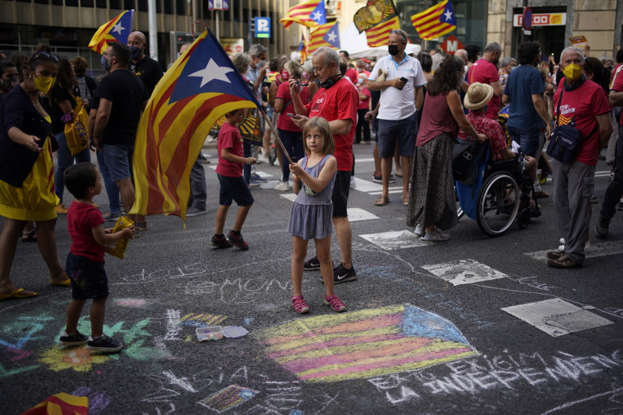 A girl waves a pro-independence flag as demonstrators march during the Catalan National Day in Barcelona, Spain, Saturday, Sept. 11, 2021. Thousands of Catalans have rallied for independence from the rest of Spain in their first major mass gathering since the start of the pandemic. The march in Barcelona on Saturday comes before a meeting between regional leaders in northeast Catalonia and the Spanish government.