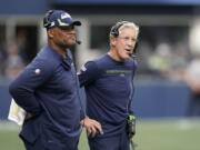 Seattle Seahawks head coach Pete Carroll, right, stands with defensive coordinator Ken Norton Jr., left, stand on the sidelines during Sunday's game against the Tennessee Titans in Seattle.