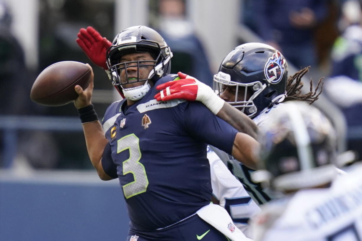 Seattle Seahawks quarterback Russell Wilson is pressured by Tennessee Titans outside linebacker Bud Dupree, right, late in the fourth quarter.