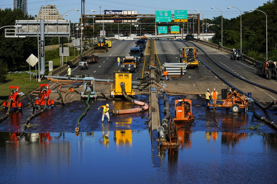Workers pump water from a flooded section of Interstate 676 in Philadelphia Friday, Sept. 3, 2021 in the aftermath of downpours and high winds from the remnants of Hurricane Ida that hit the area.  The cleanup and mourning has continued as the Northeast U.S. recovers from record-breaking rainfall from the remnants of Hurricane Ida.