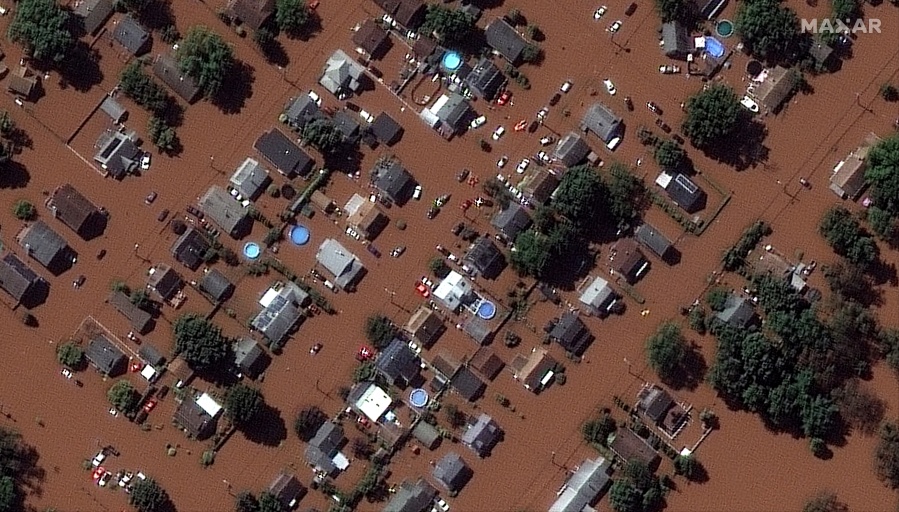 In a satellite image provided by Maxar Technologies, homes along Boessel Ave., in Manville, N.J. are surrounded by floodwaters Thursday, Sept.