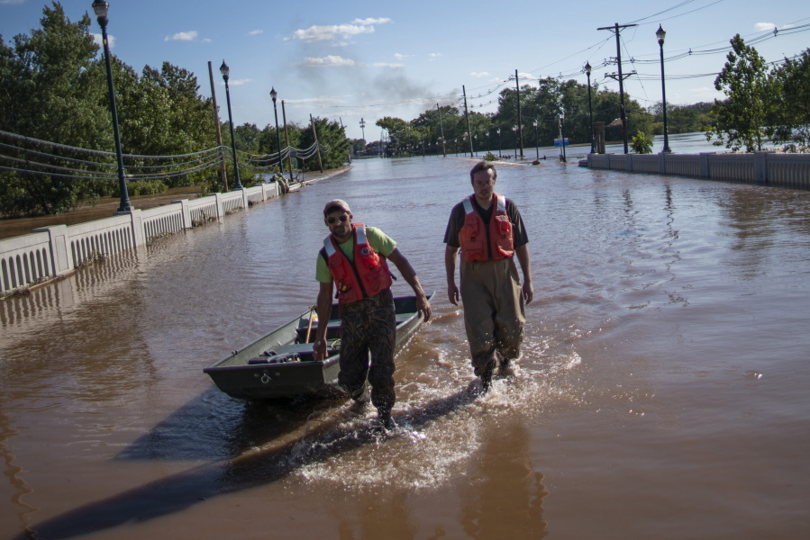 United States Geological Survey workers push a boat as they look for residents on a street flooded as a result of the remnants of Hurricane Ida in Somerville, NJ., Thursday, Sept. 2, 2021.