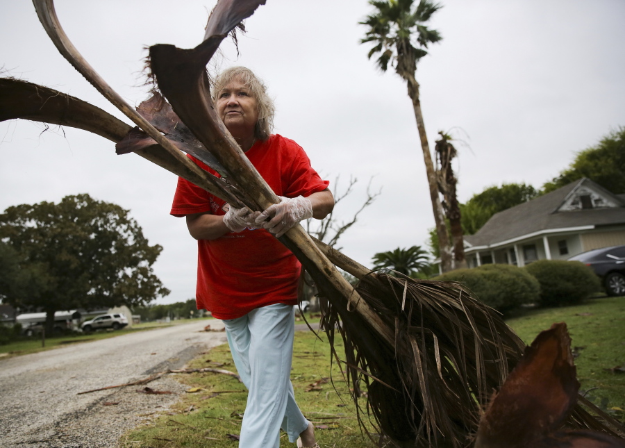 Alfa Alamia cleans up her brother's yard in Palacios, Texas following Hurricane Nicholas on Tuesday, Sept. 14, 2021. Alamia has lived in Palacios since she was 12.