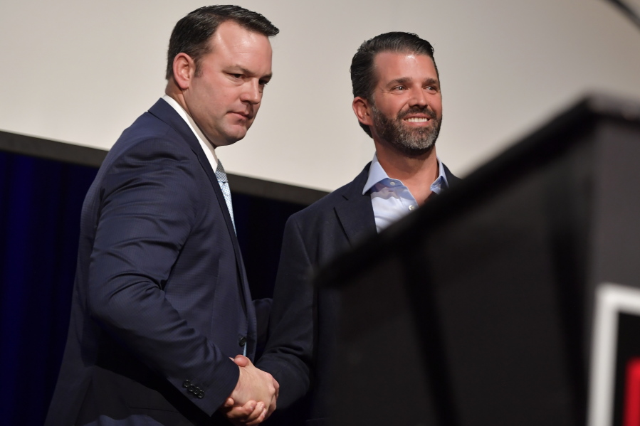 Donald John Trump Jr., right, shakes hands with Georgia state Sen. Burt Jones who is running for Lt. Governor, Wednesday, Sept. 22, 2021, in Marietta, Ga. The rewards of an early Donald Trump endorsement will be on display Saturday in Georgia. A three-man ticket of candidates he's backing in 2022 Republican primaries for statewide office will take the stage with him.  Completing the trio is Jones, an early Trump supporter who pushed measures to overturn President Joe Biden's Georgia win.