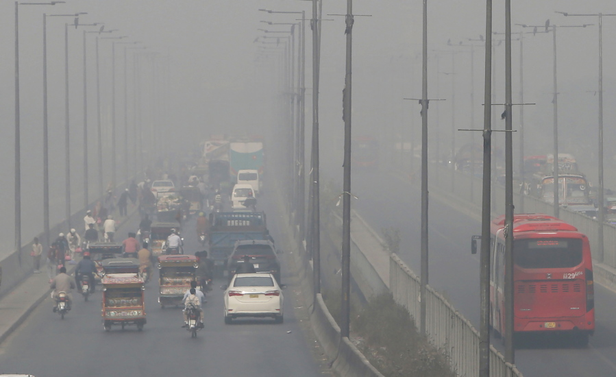 FILE - In this Wednesday, Nov. 11, 2020 file photo, vehicles drive on a highway as smog envelops the area of Lahore, Pakistan. The World Health Organization said Wednesday Sept. 22, 2021, the negative health impacts of poor air quality kick in at lower levels than it previously thought, announcing revisions to its guidelines on air quality that set a higher bar for policymakers in a world where 90 percent of people already live in areas with one particularly harmful type of pollutant. (AP Photo/K.M.