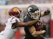 Washington State running back Max Borghi, right, carries the ball while pressured by Southern California cornerback Isaac Taylor-Stuart during the first half of an NCAA college football game, Saturday, Sept. 18, 2021, in Pullman, Wash.