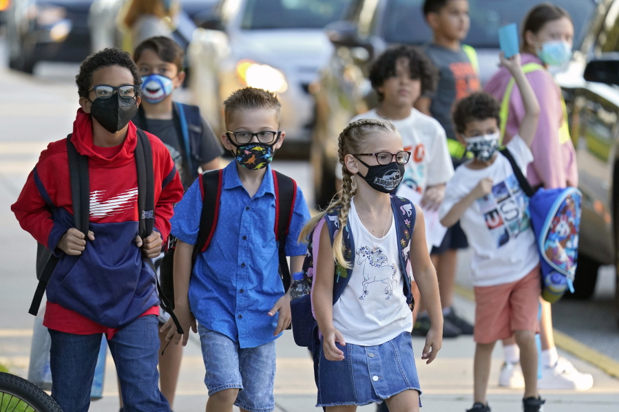 Students wearing protective masks arrive for the first day of school at Sessums Elementary School in Riverview, Fla., on Aug. 10.