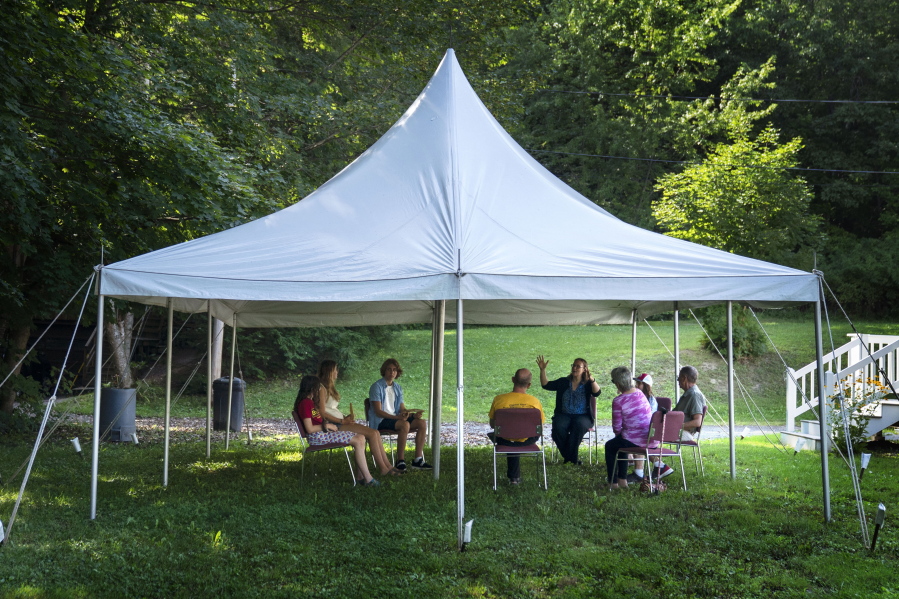 A class in Judaism is held under a tent set upon outside Temple Beth El, Monday, Aug. 30, 2021, in Augusta, Maine. The recent COVID-19 upsurge is disrupting plans for full-fledged in-person services. "The ability to see people face to face is wonderful, whatever way they choose to come," Rabbi Erica Asch says. "But there's a little bit of sadness that we can't all be together the way we'd like." (AP Photo/Robert F.