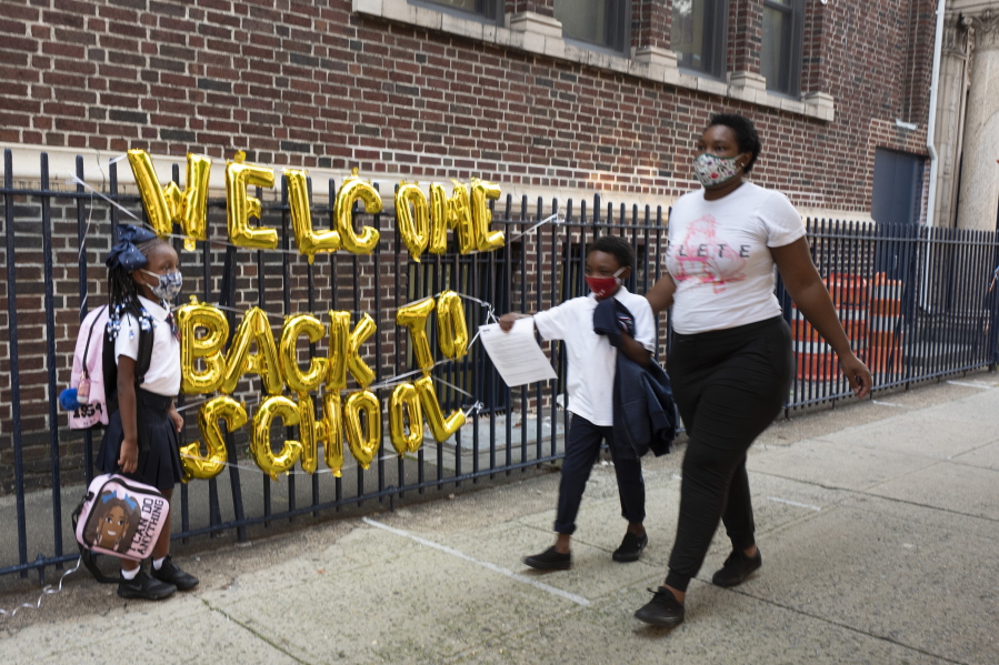 A "Welcome Back to School" hangs on a fence at Brooklyn's PS 245 elementary school as children arrive for the first day of class, Monday, Sept. 13, 2021, in New York. Classroom doors are swinging open for about a million New York City public school students in the nation's largest experiment of in-person learning during the coronavirus pandemic.