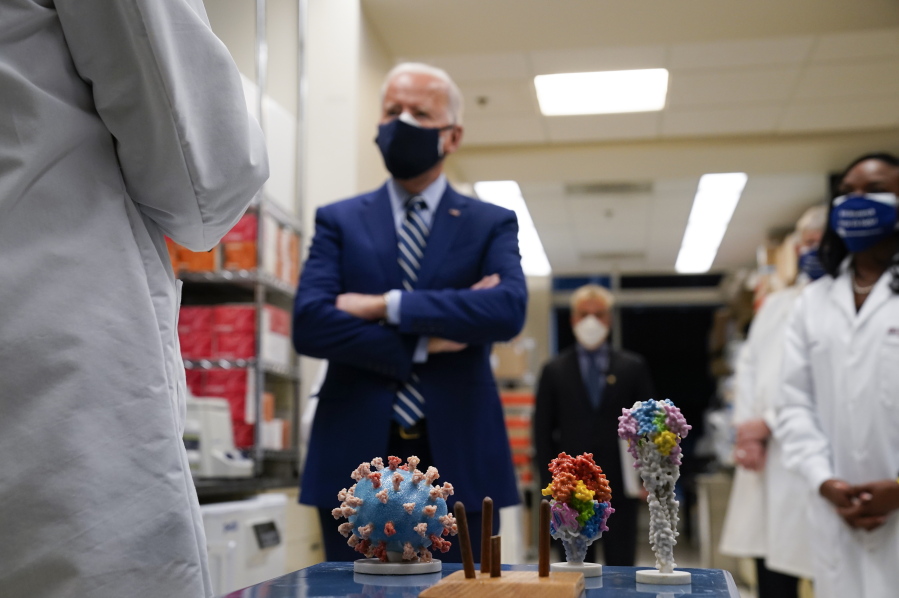 FILE - In this Feb. 11, 2021 file photo, President Joe Biden visits the Viral Pathogenesis Laboratory at the National Institutes of Health (NIH) in Bethesda, Md. This summer's coronavirus surge has been labeled a "pandemic of the unvaccinated" by government officials from President Joe Biden on down. That sound bite captures the glaring reality that unvaccinated people overwhelmingly account for new cases and serious infections.