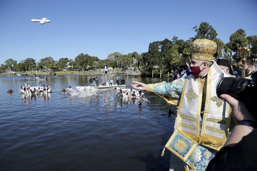 FILE - In this Wednesday, Jan. 6, 2021 file photo, His Eminence Archbishop Elpidophoros, Primate of the Greek Orthodox Archdiocese of America throws a cross into Spring Bayou during the 115th year of the annual Epiphany celebration in Tarpon Springs, Fla. Leaders of the Greek Orthodox Archdiocese of America said Thursday, Sept. 16, 2021, that while some people may have medical conditions for not receiving the vaccine, "there is no exemption in the Orthodox Church for Her faithful from any vaccination for religious reasons." Greek Orthodox Archbishop Elpidophoros added: "No clergy are to issue such religious exemption letters," and any such letter "is not valid." (Douglas R.