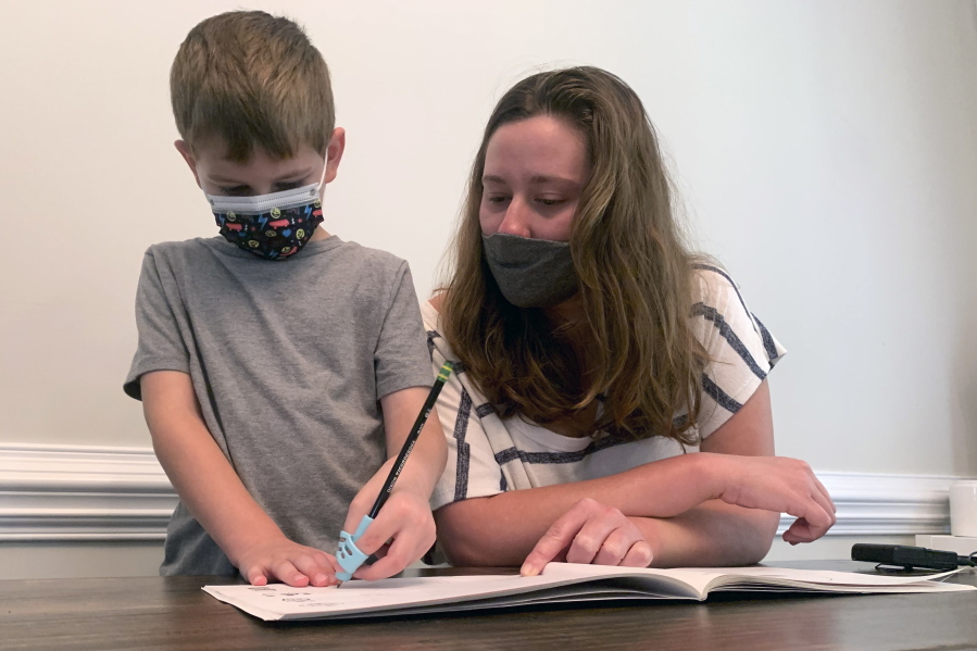 Emily Goss goes over school work at the kitchen table with her five-year-old son inside their Monroe, N.C., home on Monday, Sept. 13, 2021. The Goss' have decided to homeschool Berkeley after the Union County school district chose not to implement a mask mandate for children.
