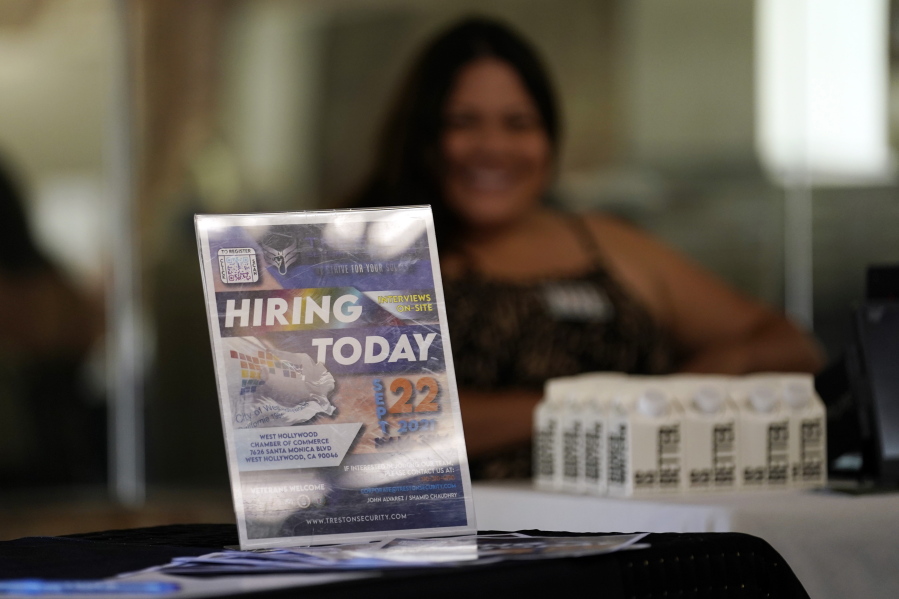 A hiring sign is placed at a booth for prospective employers during a job fair in September.(AP Photo/Marcio Jose Sanchez)