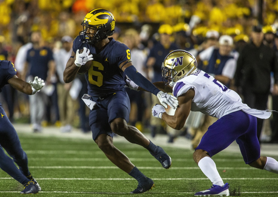 Michigan wide receiver Cornelius Johnson (6) rushes away from Washington defensive back Kyler Gordon, right, in the first quarter of an NCAA college football game in Ann Arbor, Mich., Saturday, Sept. 11, 2021.