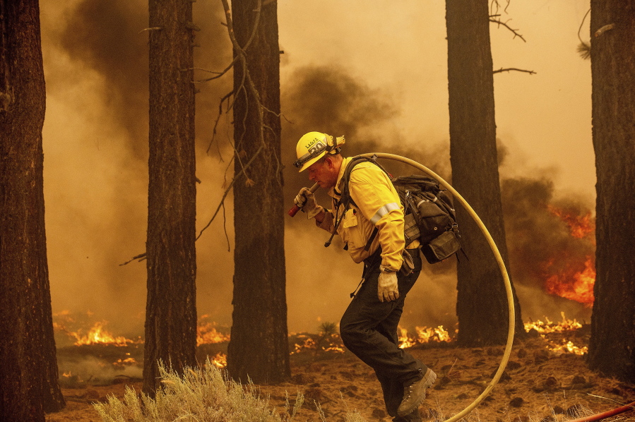 A firefighter battles the Caldor Fire along Highway 89, Tuesday, Aug. 31, 2021, near South Lake Tahoe, Calif.
