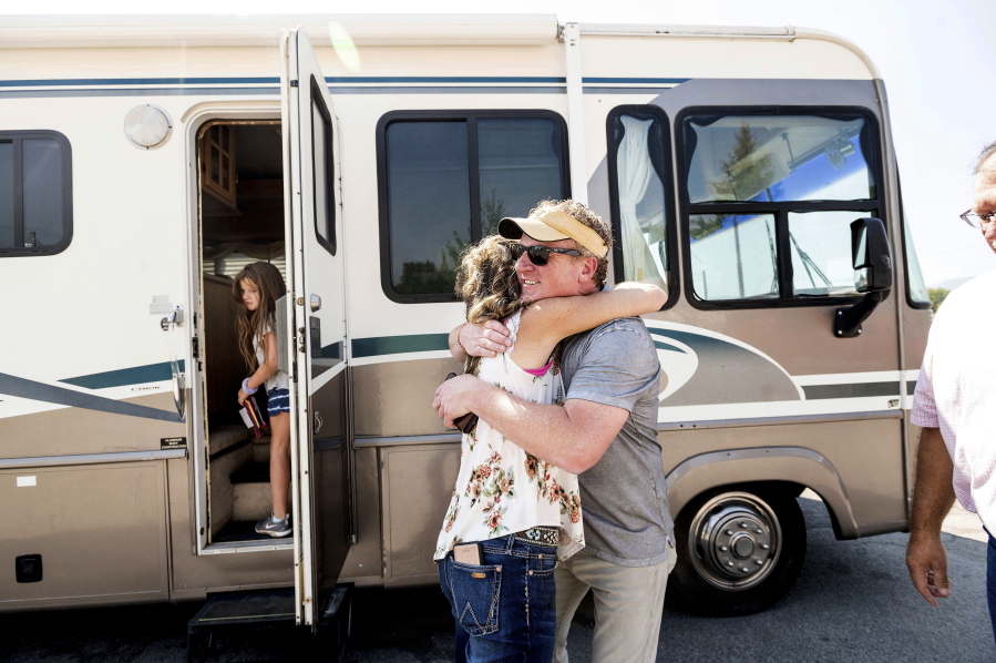 Woody Faircloth hugs Sheri Roen as her family donates their motorhome to EmergencyRV.org on Sept. 5 in Sierra County, Calif. Accompanied by daughter Luna, left, Faircloth delivered it to a Dixie Fire victim later that day.