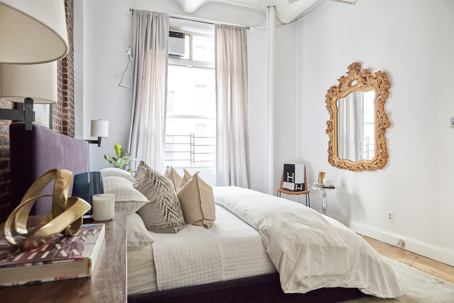 A gold mirror and gold accessories add a pop of metallic to this master bedroom.