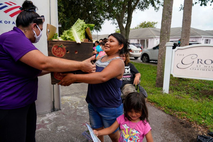 Lorena Sanchez, 23, from Guatemala, picks up fruits and vegetables Sept. 16 during a twice-monthly visit to Wimauma, Fla., by the Veggie Van, a mobile marketplace operated by the Tampa Metropolitan Area YMCA.