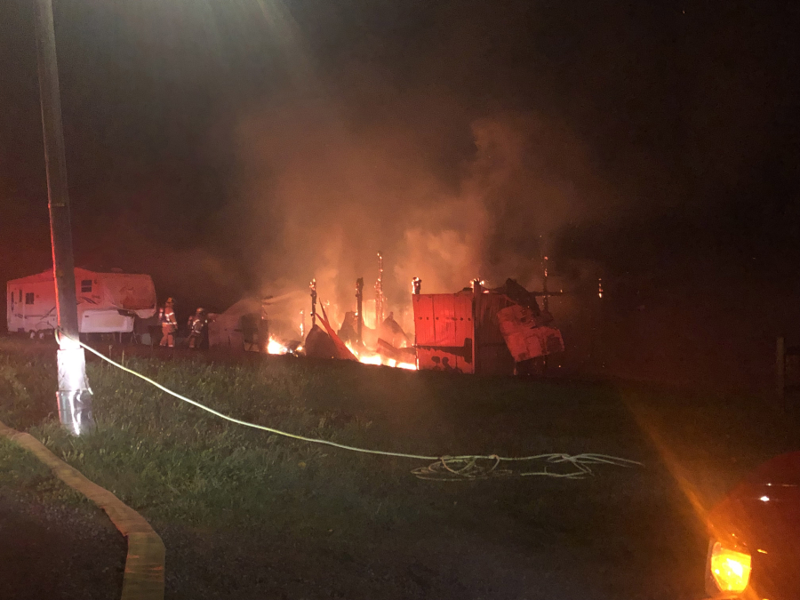 A barn burns in Woodland Monday morning after a heat lamp fell during blustery winds. Three goats inside were rescued from the fire, the fire department said.