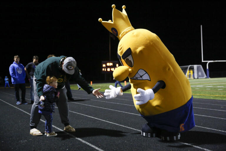A young fan meets the Ridgefield Spudders team mascot during a 2A Greater St. Helens League football game at Ridgefield High School on Thursday, Oct. 7, 2021.