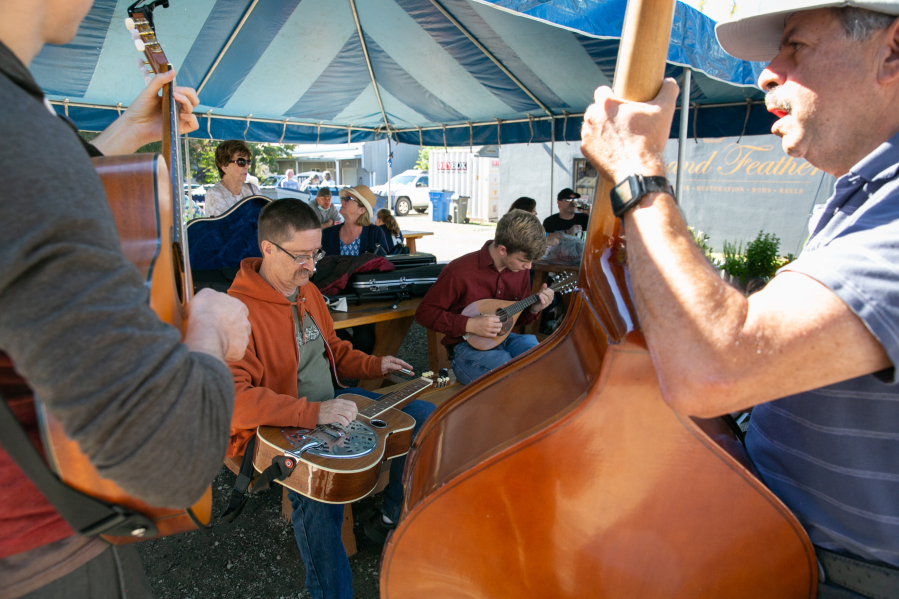 From left: Roger Vanderveen, seated, on dobro guitar; Nate Hendricks, 16, on mandolin; and Jon Rand on the upright bass perform during the 21st annual BirdFest & Bluegrass festival Saturday at the Park Food Cart Pod in Ridgefield.
