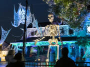 A 12-foot tall skeleton looms over people looking at Halloween decorations the Mains' house on Franklin Street in Vancouver earlier this month.