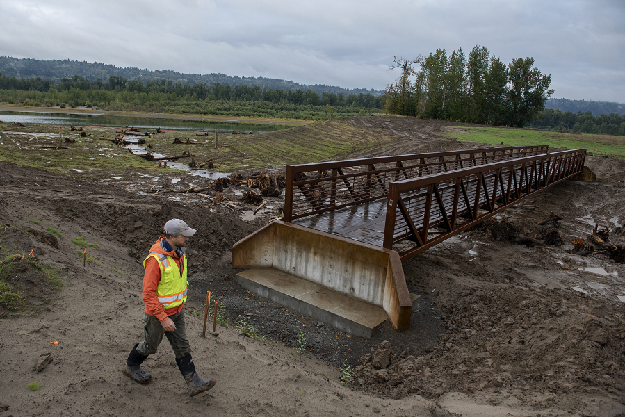 Chris Collins, project manager for the Lower Columbia Estuary Partnership, walks past a new trail bridge crossing the levee breach to the Columbia River at the Steigerwald Lake National Wildlife Refuge on Wednesday morning.