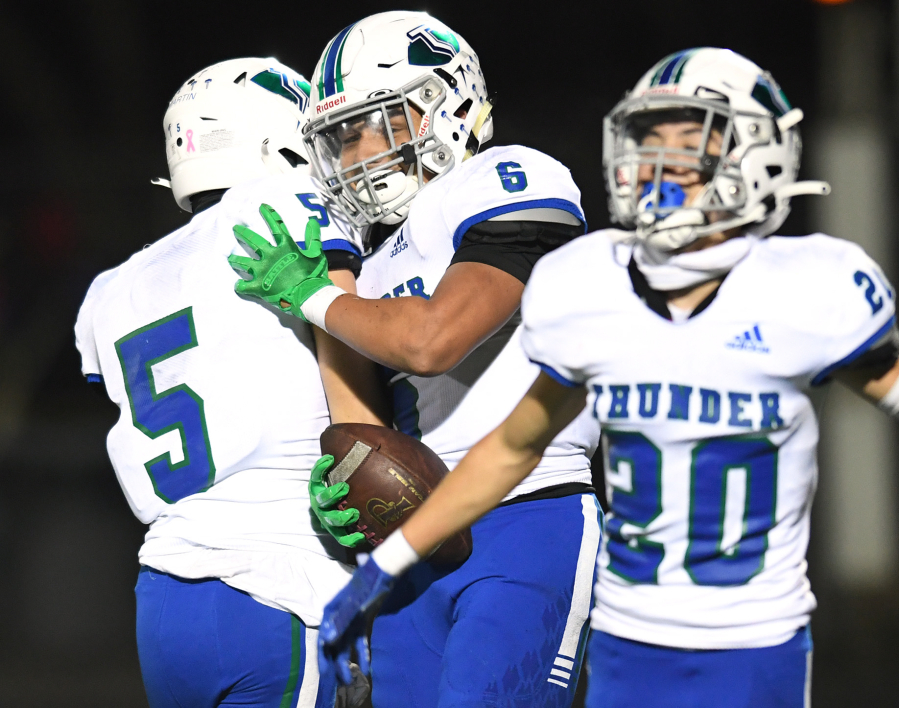 Mountain View senior CJ Hamblin (6) celebrates with teammates after making an interception Friday against Prairie in the 3A Greater St. Helens League game at District Stadium in Battle Ground. The Thunder won 17-14.