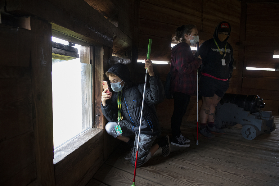 Above, seventh-grader Dezmynd Cantu, left, kneels to snap a photo while touring the bastion at Fort Vancouver National Historic Site with classmate Brianna Hoefliner and paraeducator Jared Miller-Price.