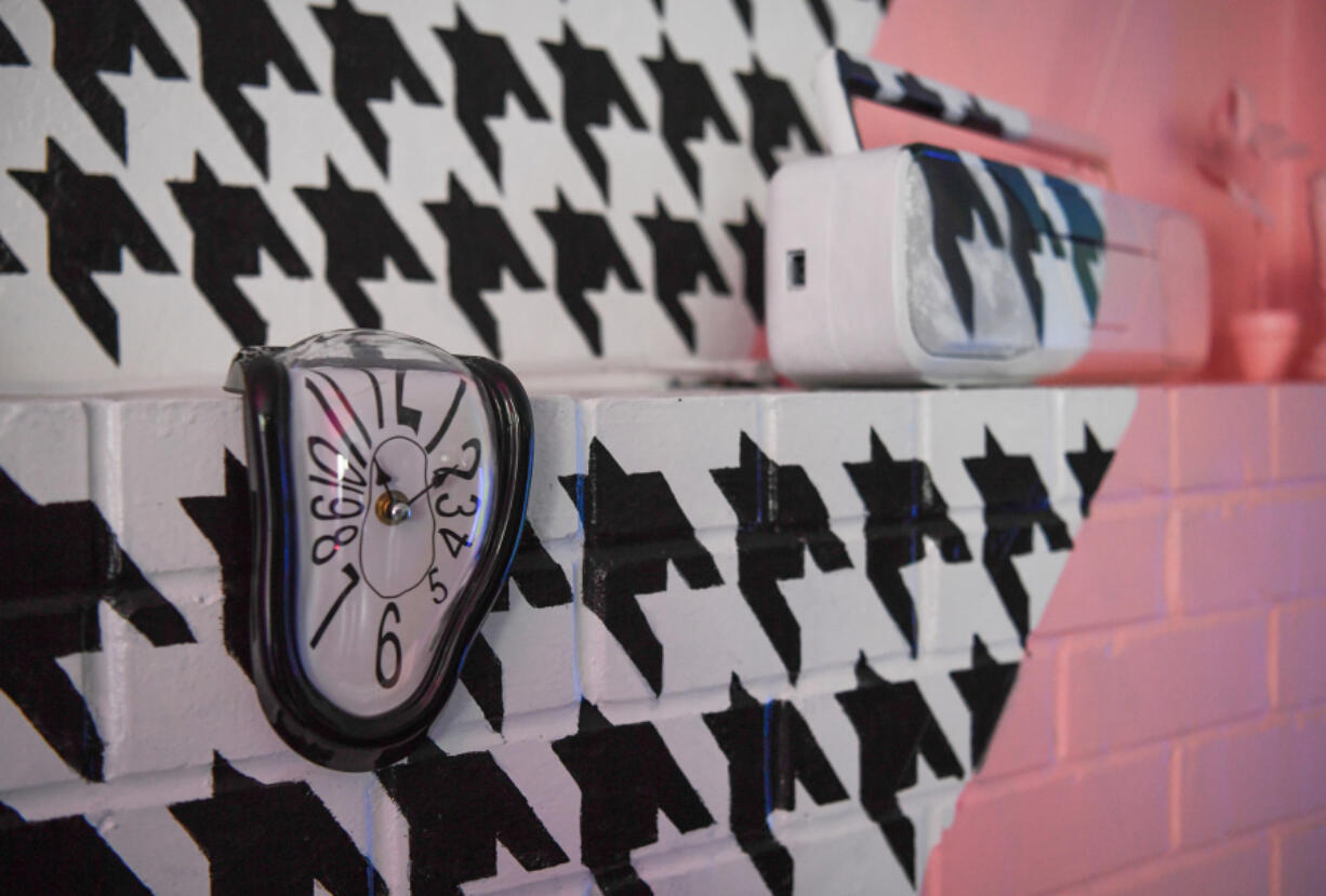 A melting clock sits on a houndstooth-patterned wall at The Haus of Luna art installation Vancouver.