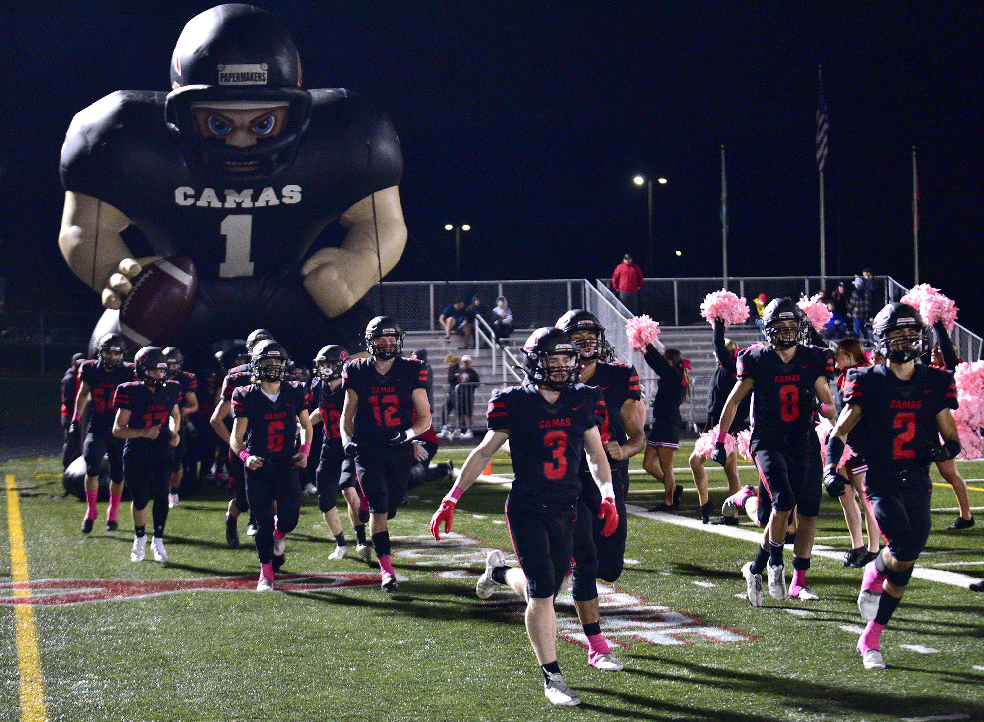 Camas High School football players run onto the field Friday, Oct. 22, 2021, before a game between the Papermakers and Skyview at Camas High School.